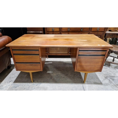 1027 - Mid-century teak desk, the central recess flanked by writing slide and three graduating drawers, the... 