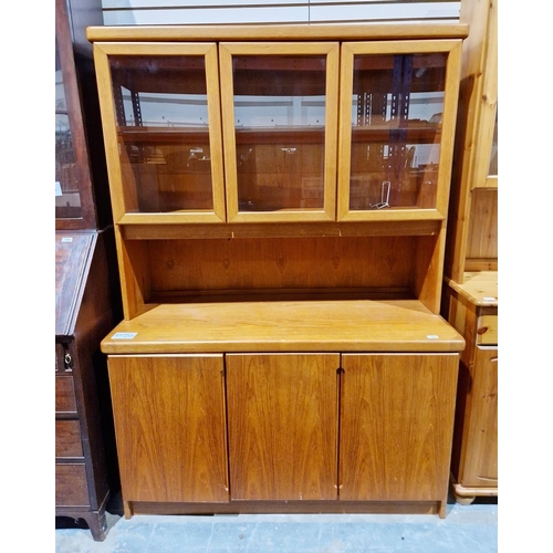 1063 - Mid-century teak sideboard, the top section having three glazed cupboards, each with a single drawer... 