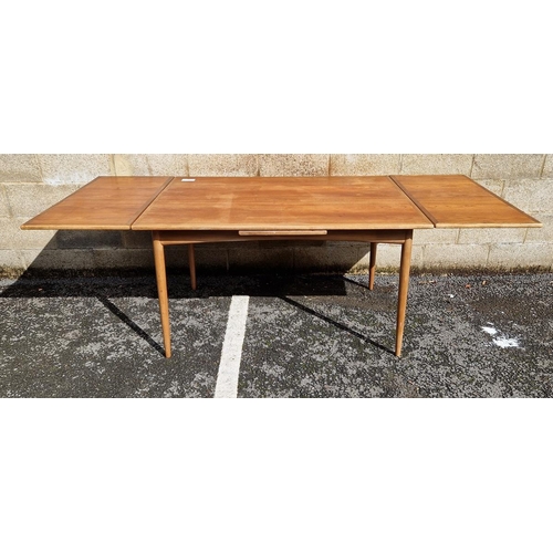 1071 - Mid-century teak draw-leaf dining table, of rectangular form, on rounded tapering legs, possibly by ... 