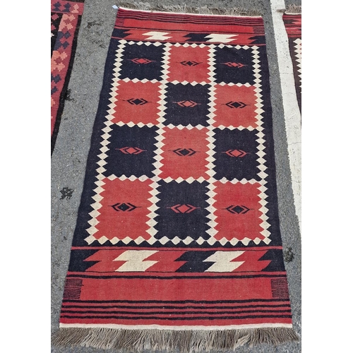 1240 - Two vintage Afghan rugs, each with chequerboard design in red and dark brown within cream lozenge-sh... 