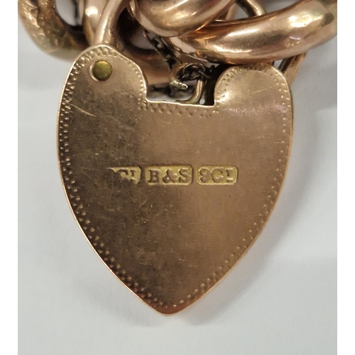 223 - 9ct rose gold curb-link charm bracelet with engraved padlock clasp and an assortment of antique gold... 