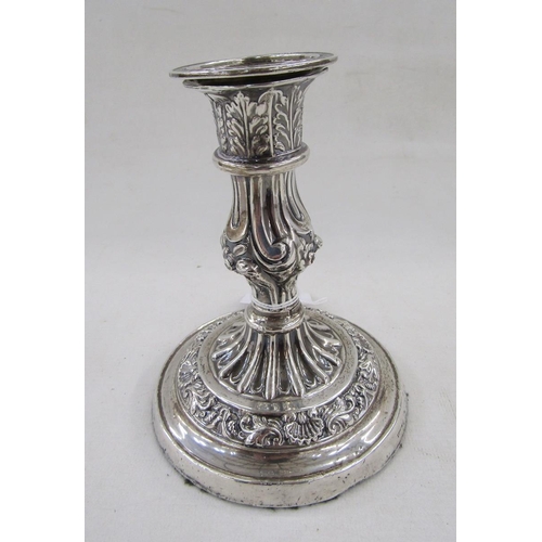 28 - White metal single candlestick, with embossed acanthus leaf and scallop shell decoration, measuring ... 