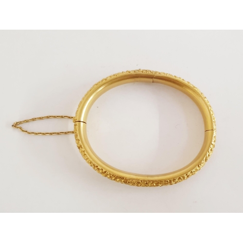 321 - 18ct gold bangle, all flowerhead embossed and with safety chain, 25g (repair to the centre of one ha... 