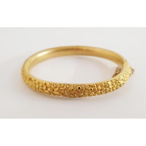 321 - 18ct gold bangle, all flowerhead embossed and with safety chain, 25g (repair to the centre of one ha... 