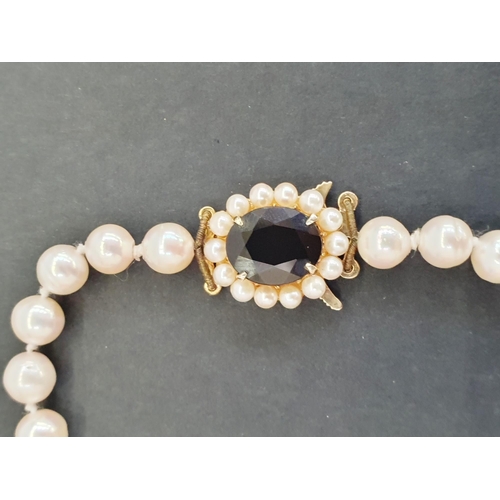 376 - Cultured pearl necklace, single-strand and the 9ct gold clasp set garnet and pearl cluster