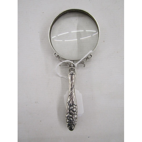 54 - Late 19th/early 20th century silver magnifying glass, with embossed floral motifs adorning the handl... 