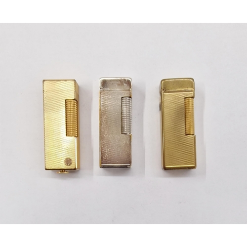 546 - Three mid-century Dunhill lighters, comprising a silver-plated engine turned example and two gold-pl... 