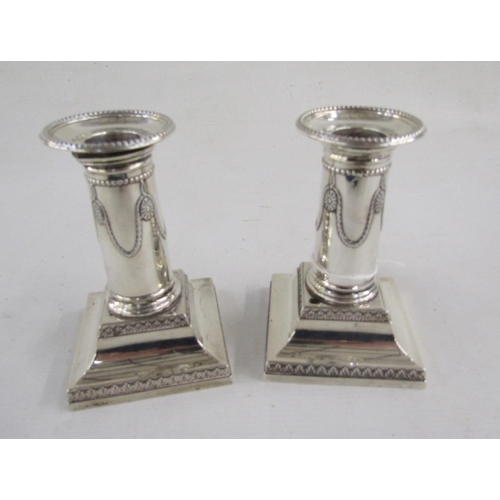 81 - Late Victorian silver pair of squat candlesticks, with wreath and beaded decoration, square bases, h... 