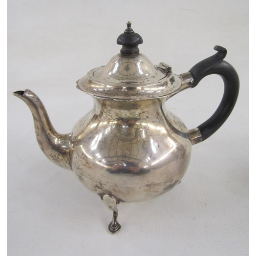 88 - George V bachelor's silver teapot and matching hot water jug, having serpentine everted rim, ebonise... 