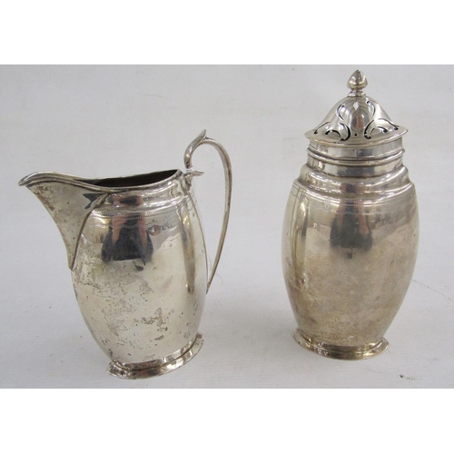 95 - George V silver sugar caster and matching cream jug, each flattened oval, engraved with shield, husk... 