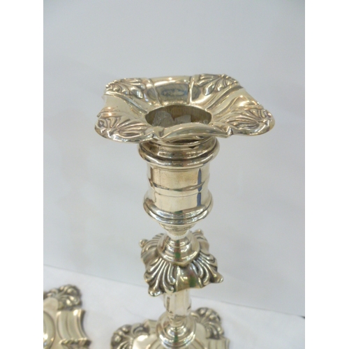 82 - A pair of Edwardian silver table candlesticks, each with anthemion decorated shaped , square drip-tr... 