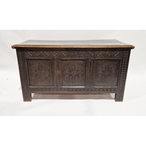 1052 - Antique oak coffer, the planked top with lunette frieze, the three-framed panel front scroll carved ... 