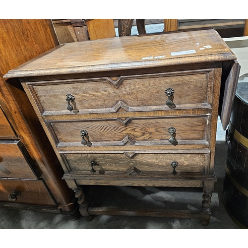 1134 - Oak chest of drawers comprising three long drawers, each with two brass handles and drop flap to sid... 