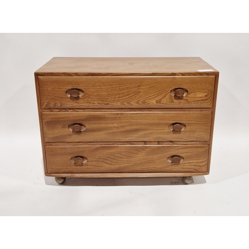 1150 - Ercol Windsor pattern blonde chest of three long drawers, raised on original castors, 67cm high x 91... 