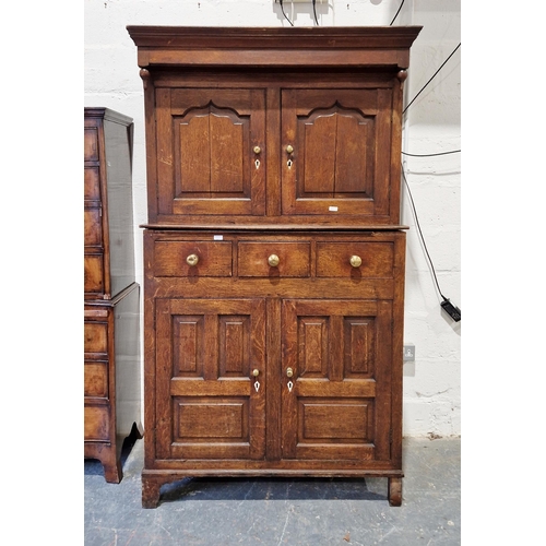 1217 - Georgian oak Welsh cupboard, the top section with double panelled cupboard doors enclosing shelves f... 