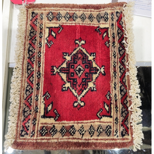 1264 - Bokhara rug with single lozenge on a cherry red ground, 24cm x 33cm