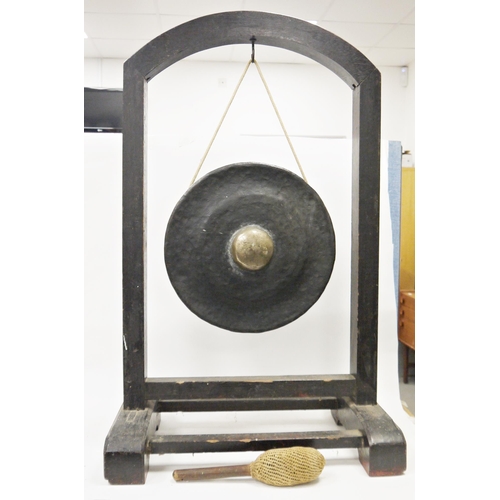 127 - South East Asian bronze temple gong on ebonised stand, the circular gong with central boss, suspende... 