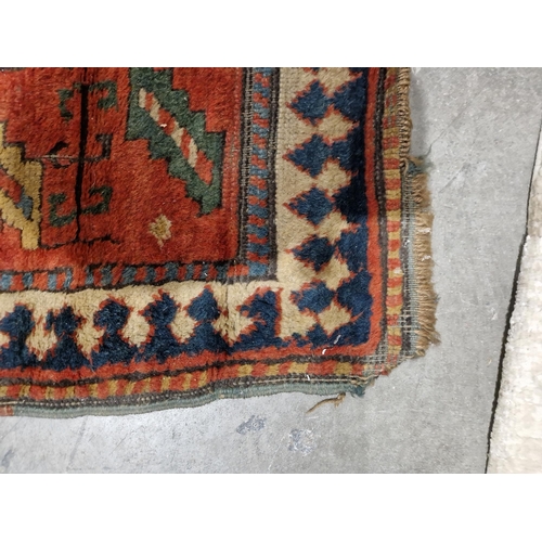 1283 - Caucasian rug with central hooked lozenge on green ground flanked by hooked squares with floral moti... 