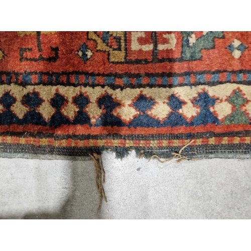 1283 - Caucasian rug with central hooked lozenge on green ground flanked by hooked squares with floral moti... 