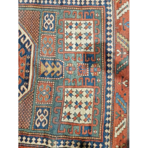 1283 - Caucasian rug with central hooked lozenge on green ground flanked by hooked squares with floral moti... 