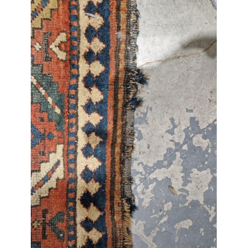 1283 - Caucasian rug with central hooked lozenge on green ground flanked by hooked squares with floral moti... 