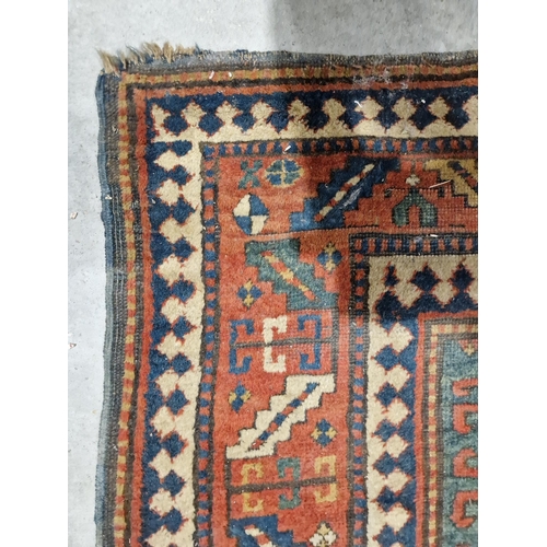 1283 - Caucasian rug with central hooked lozenge on green ground flanked by hooked squares with floral moti... 