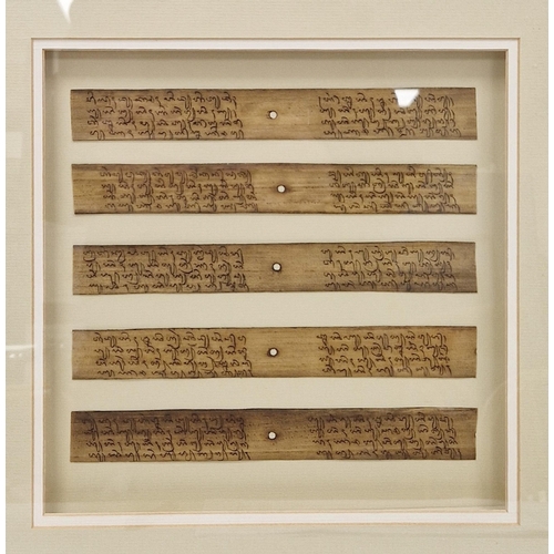 131 - Five reproduction Asian written palm leaves, depicting religious texts, framed and glazed