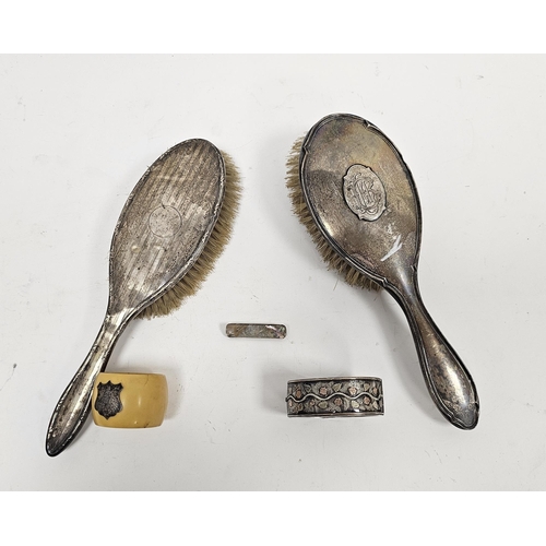 278 - Two silver-mounted dressing table brushes, one with monogrammed initials, a white metal hinged bangl... 