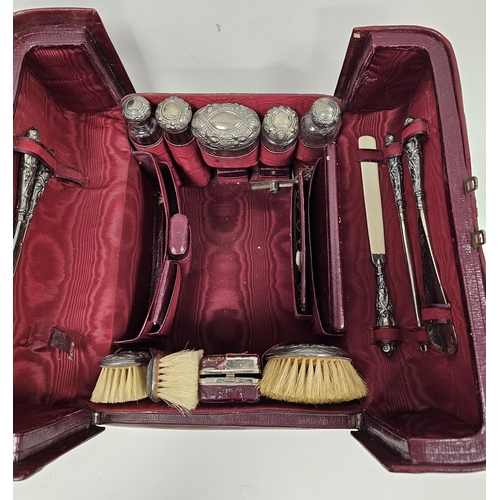 309 - Edwardian red leather travelling gladstone style silver mounted vanity set, containing silver mounte... 