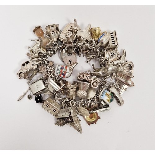 353 - 20th century silver and white metal charm bracelet, with an assortment of attached charms including ... 