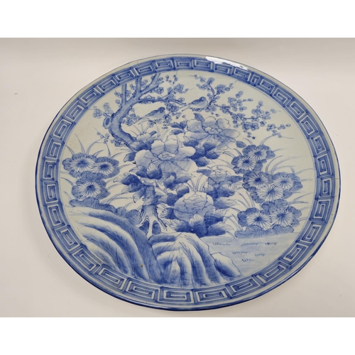 85 - Large Japanese blue and white porcelain charger, circa 1900, painted with flowers, prunus and a bird... 