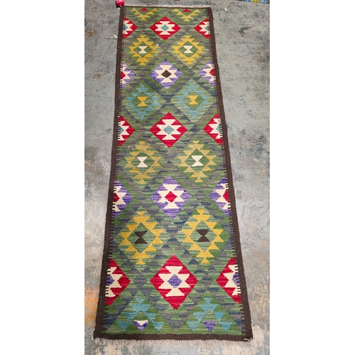 1205 - Maimana kilim runner, 217cm x 68cm , having allover geometric filled lozenge decoration in green, re... 