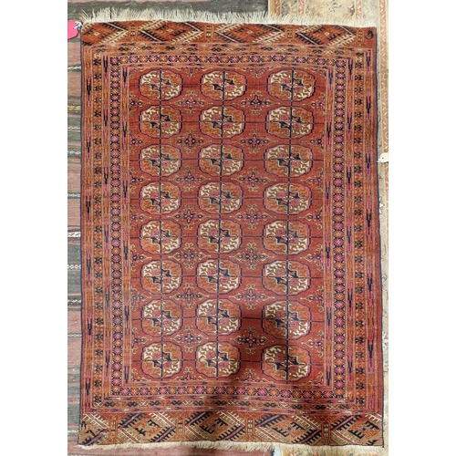 1189 - Eastern red ground rug with three rows of eight quartered elephant foot guls, on geometric field wit... 