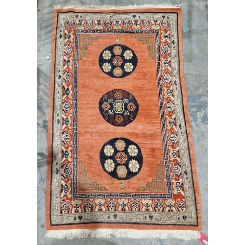 1200 - Oriental-style red ground rug, the central panel with three circular floral medallions and spandrels... 