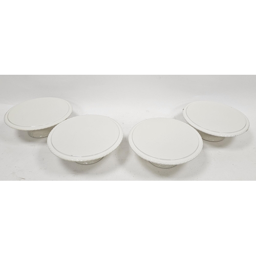 55 - Four cream glazed pottery cake stands, of circular form, on spreading bases, 28.5cm diam. (4)