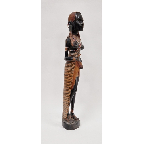 152 - Carved wooden figure of an African girl with beaded decoration to her ankles and chest, 62cm high