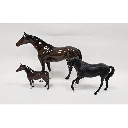 25 - Three Beswick pottery models of horses comprising a large chestnut coloured horse, 35cm long, anothe... 