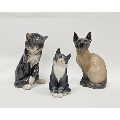 40 - Three Royal Copenhagen porcelain models of cats, each modelled seated, one modelled as a Siamese, pr... 