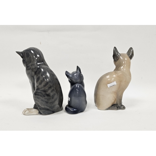 40 - Three Royal Copenhagen porcelain models of cats, each modelled seated, one modelled as a Siamese, pr... 