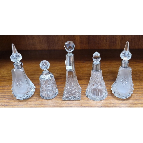 474A - Four Victorian and Edwardian silvered collared cut-glass perfume bottles and a white metal mounted e... 