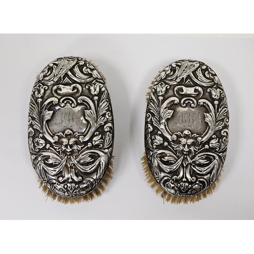 483 - Pair of Victorian silver backed oval clothes brushes, each in repousse with masks and scrolling acan... 