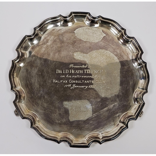 495 - Silver salver, circular with serpentine border and inscription to “Dr I D Heath” to the front, on sc... 