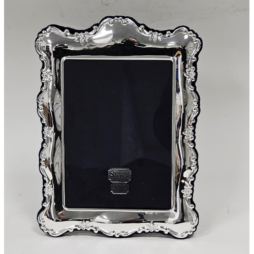 527 - Contemporary silver photograph frame, of rectangular rocaille moulded form, backed in blue velvet wi... 