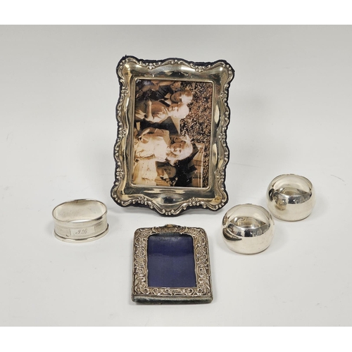 575 - Three various silver napkin rings, silver photograph frame, rectangular with scroll and foliate bord... 