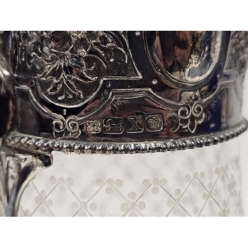 587 - A mid Victorian silver and cut glass claret jug, the circular hinged cover engraved with family cres... 