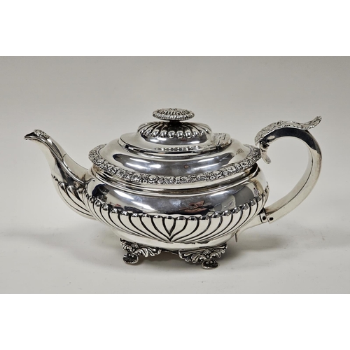 618 - A George III silver boat shape demi gadrooned teapot, gadrooned hinged cover with oval foliate finia... 