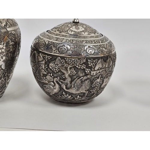 640 - Pair of Persian/Iranian white metal vases of baluster form, densley decorated with shaped cartouches... 