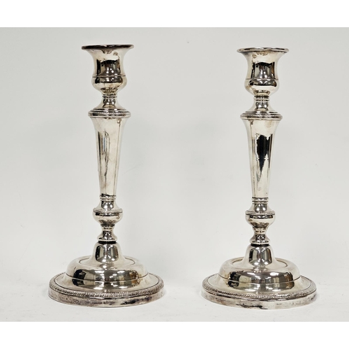 642 - Pair white metal candlesticks, unmarked, each with bell-shaped sconce, shouldered tapering column, o... 