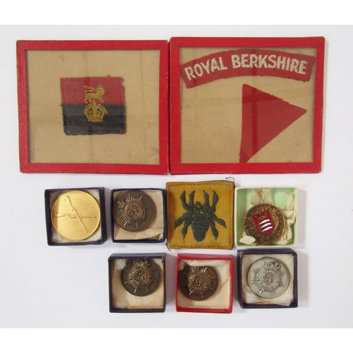 225 - Collection of British Army cap badges, cloth badges, rank markings and shooting medals.