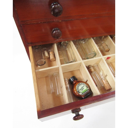 414 - Stained wood apothecary's cabinet having eight graduated drawers with bun handles, containing homeop... 